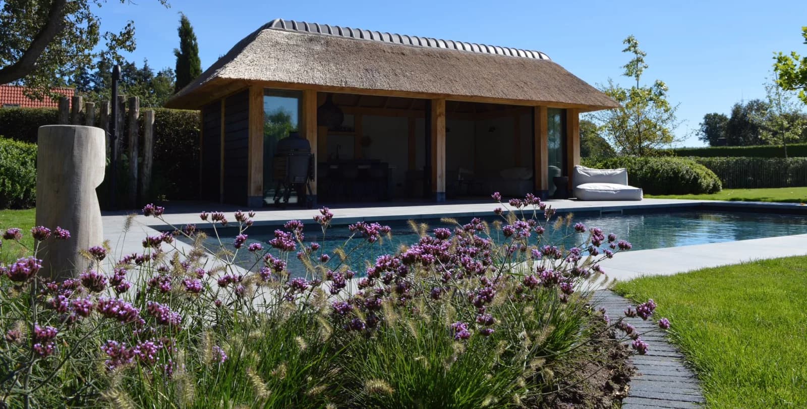 Swimming pool with pool house, installed by Hartog Outdoor Living